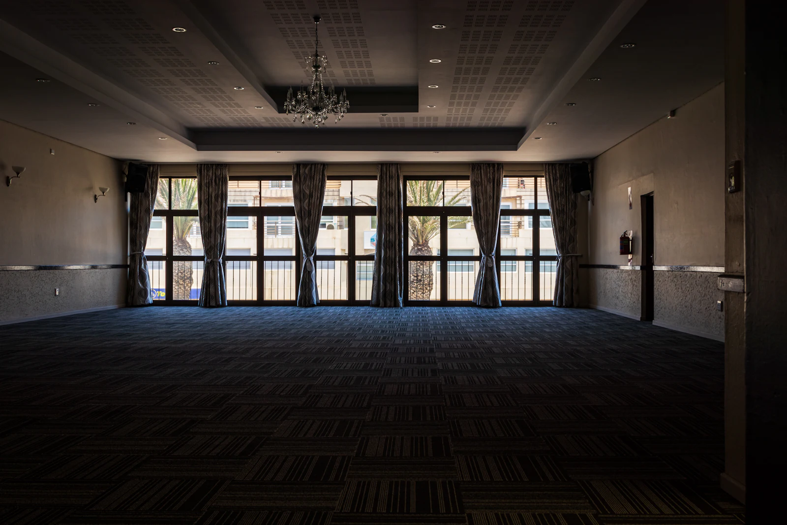 An empty ballroom before an event, lit in cool blue