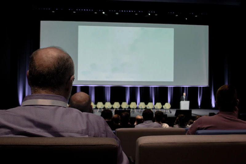 Delegates watching a presentation on a large projection screen